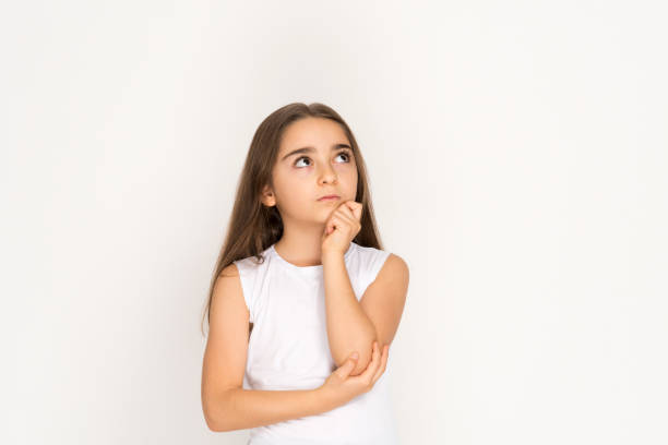 istock Little girl looking up thinking searching for ideas or debating 1203030896
