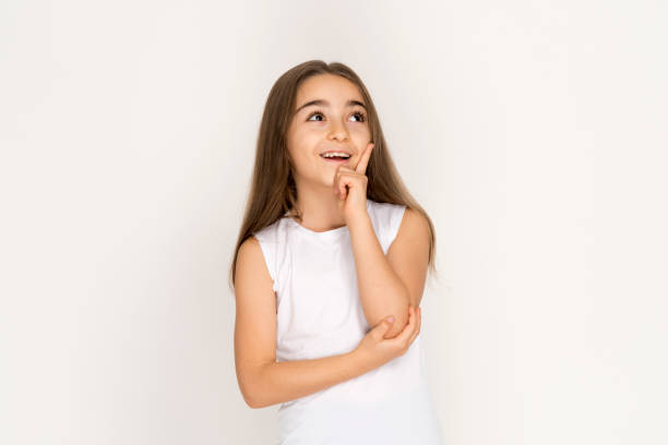 istock Little girl looking up thinking searching for ideas or debating 1203030904