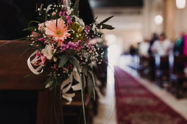 istock Beautiful flower wedding decoration in a church. Selective focus. Unrecognizable guests on background. Marriage concept in church 1203032700