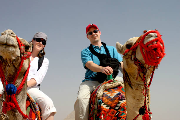 istock Camel in dessert 2 people riding trip 1203034017