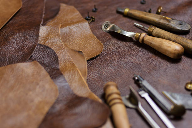 escritorio de artesano de cuero. piezas de cuero y herramientas de trabajo sobre una mesa de trabajo. - piel textil fotografías e imágenes de stock