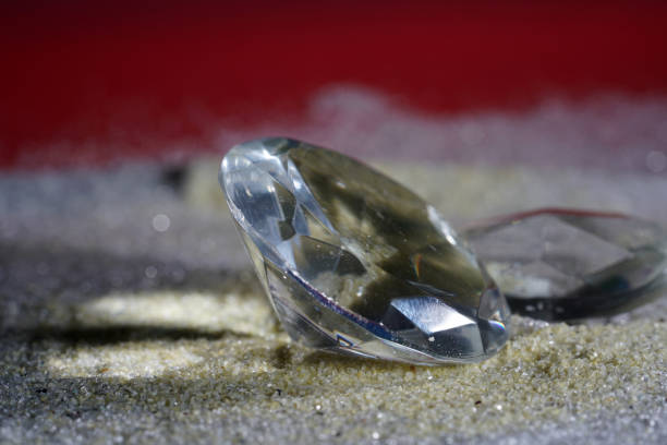 istock Artificial diamonds lying in the sand photographed in the studio with flash light 1203035643