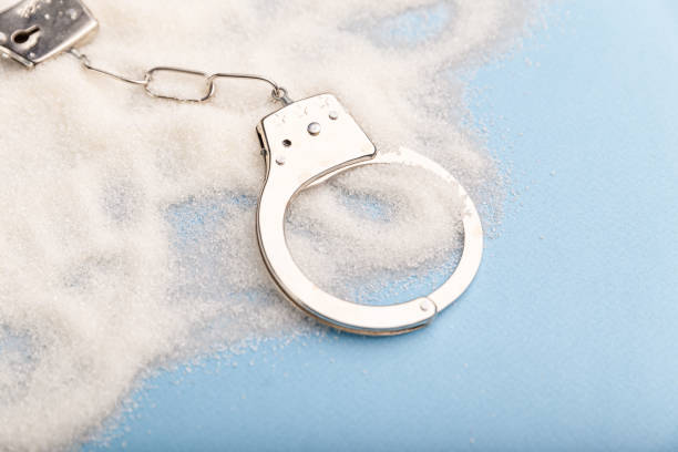 istock Sugar is dangerous. Handcuffs on the table. Sweet dependence. 1203035765