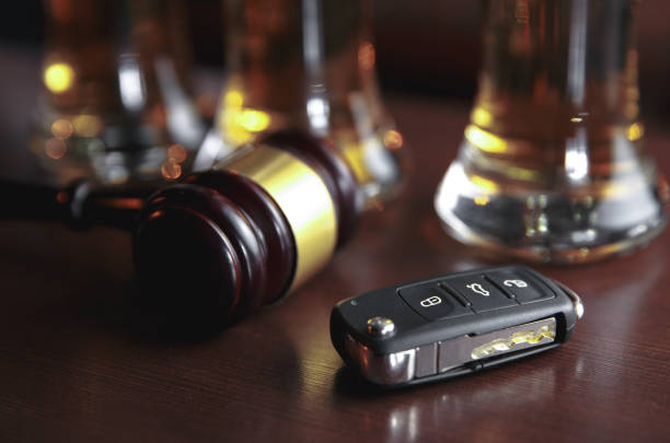 istock Drinking and driving concept. Car key on a wooden table, pub 1203037227