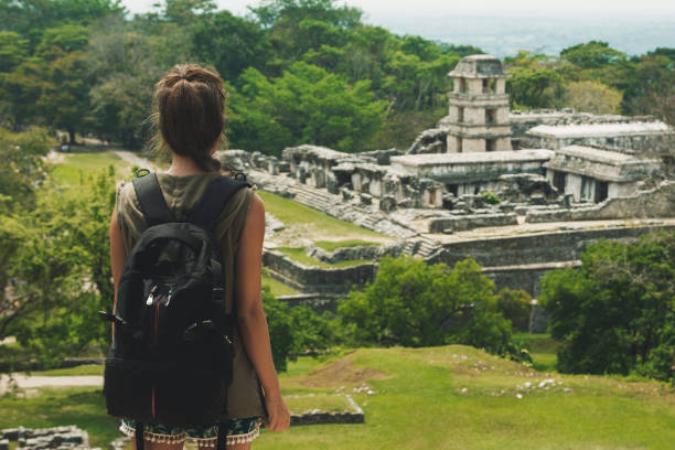 istock Woman with a backpack beside ancient Mayan ruins 1203037342
