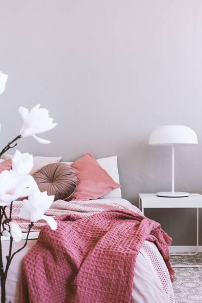 istock White industrial lamp on simple nightstand table next to cozy bed with pink bedding 1203040105