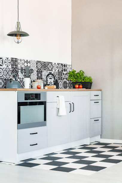 istock Trendy white kitchen interior with elegant wooden cupboards and kitchen accessories 1203040426