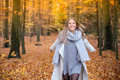 Girl walking in the park in autumn and smiles