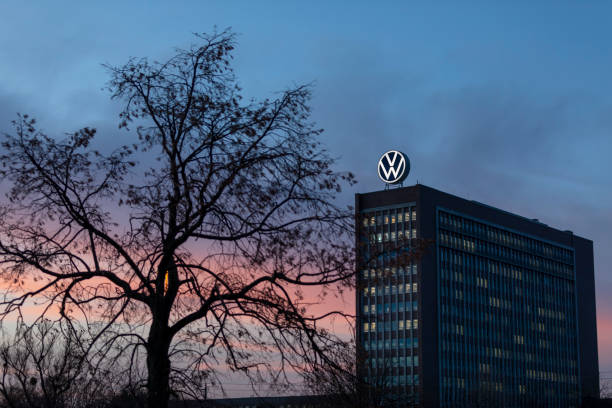 Volkswagen old head-quarters facade in Wolfsburg sunset Wolfsburg, Germany - jan 30th 2020: Volkswagen old headquarters is a visible landmark in city of Wolfsburg. Massive VW -logo on top of the building is illuminated and visible at all times. lower saxony photos stock pictures, royalty-free photos & images