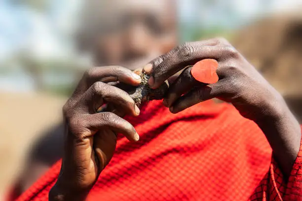 Photo of African man holding a smoldering cake in his hands with a red heart ring.