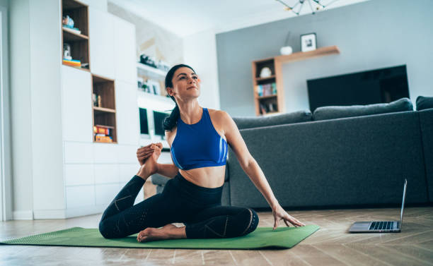 женщина, практикующая йогу дома - 20s athlete muscular build balance стоковые фото и изображения