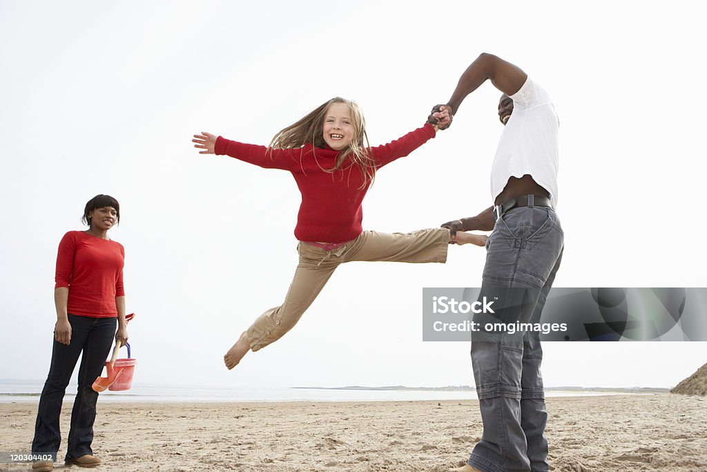 Young Family Having Fun On Beach Young Family Having Fun Playing On Beach 20-29 Years Stock Photo