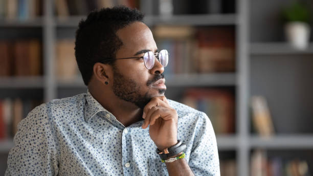 istock Thoughtful doubtful african businessman looking away lost in thoughts 1203044178