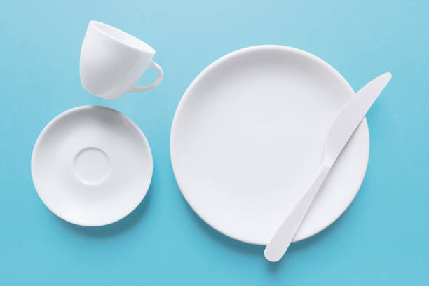 White coffee cup and dish with knife, close-up