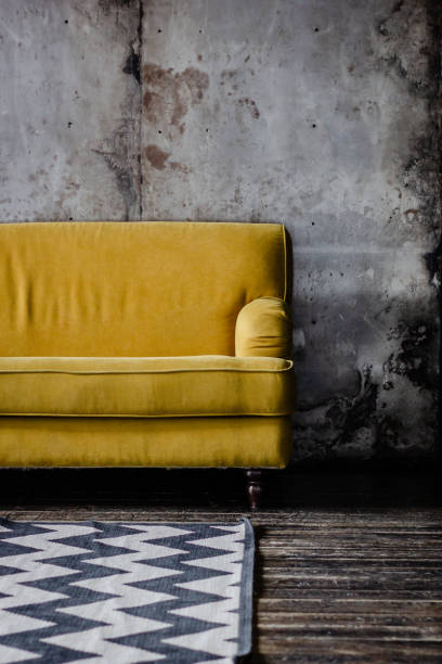 istock Yellow couch against the grey wall 1203045729