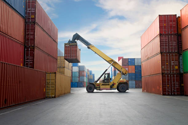 gru che solleva il contenitore in un porto. - cargo container derrick crane crane freight transportation foto e immagini stock