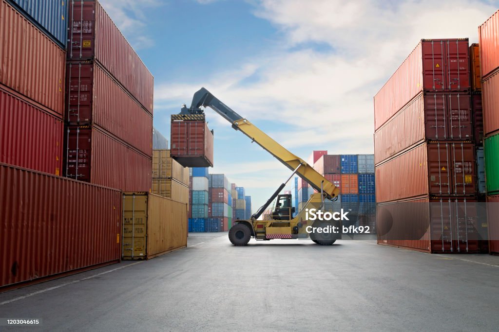 Crane lifting up container in a port. Cargo Container Stock Photo