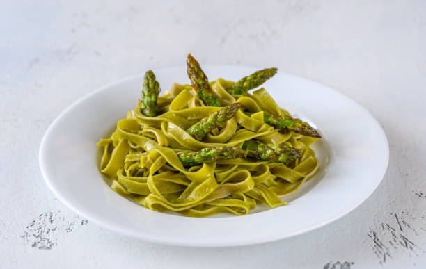 fettuccine di spinaci con asparagi fritti - pasta noodles tagliatelle freshness foto e immagini stock