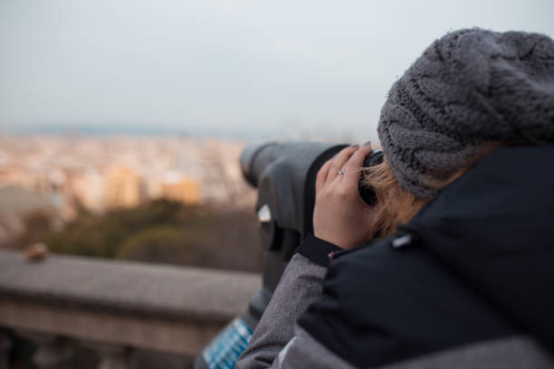 istock Young woman watching the city through binoculars 1203050205