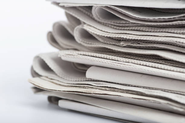 istock Newspapers folded and stacked. Pile of old newspapers on a white background. 1203050929
