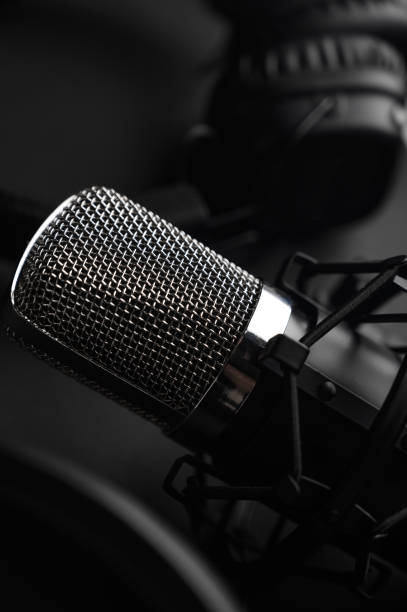 istock Microphone for podcasts and studio headphones on a black background, vertical frame 1203054860