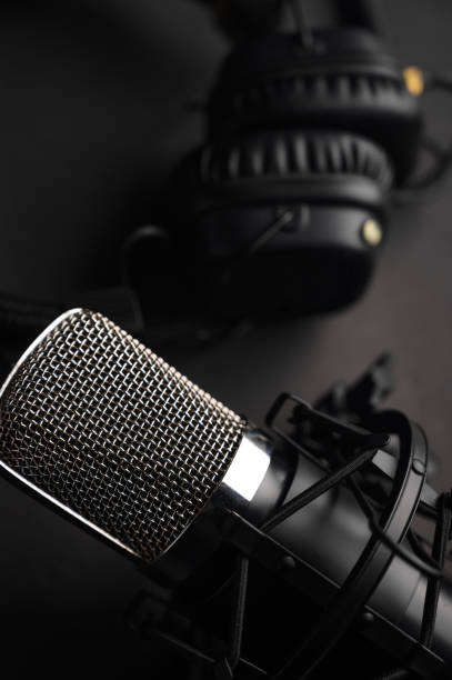 istock Studio microphone with professional headphones. Black on a black background 1203054884