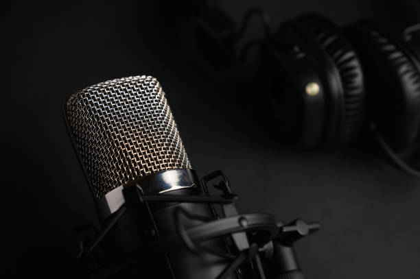 istock Microphone for podcasts and studio headphones on a black background, horizontal frame 1203054937