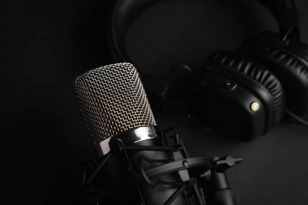 istock Microphone for podcasts and studio headphones on a black background, horizontal frame 1203054942
