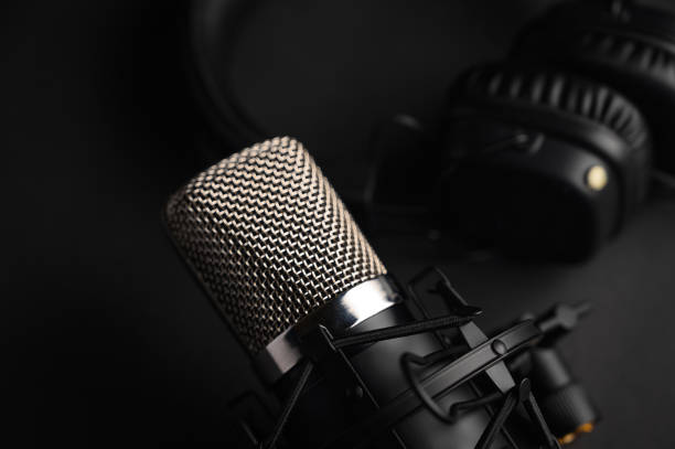 istock Microphone for podcasts and studio headphones on a black background, horizontal frame 1203054957