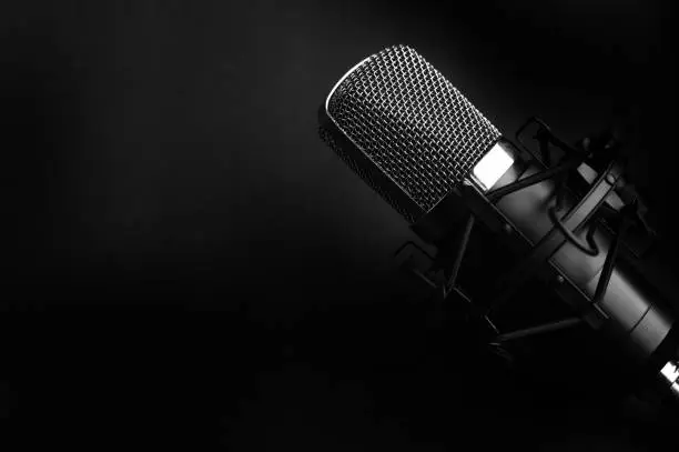 Photo of Condenser black studio microphone on a black background. Streamer, podcasts, music background