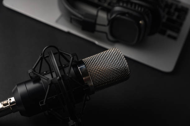 istock Blogging, podcasts, streams and broadcast, background. Black studio microphone on a laptop on a black background 1203055231