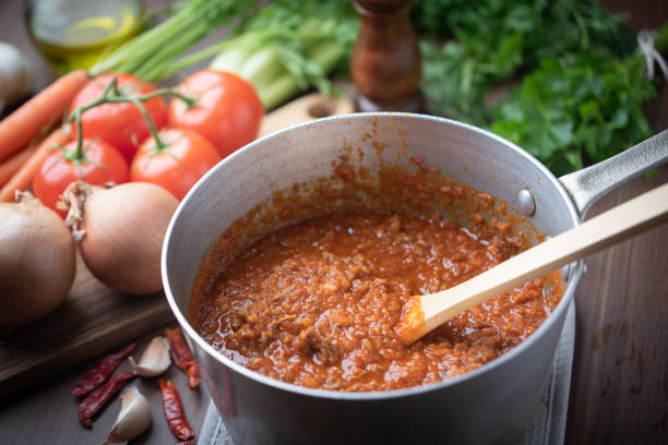 bolognaise sauce im topf mit zutaten hintergrund - ragout stock-fotos und bilder