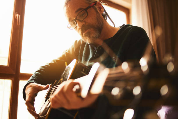 istock A man is working at home with guitar exercise 1203061844