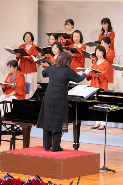 dyrygent muzyczny prowadzący chór kobiet na koncercie - conductor female women classical concert zdjęcia i obrazy z banku zdjęć
