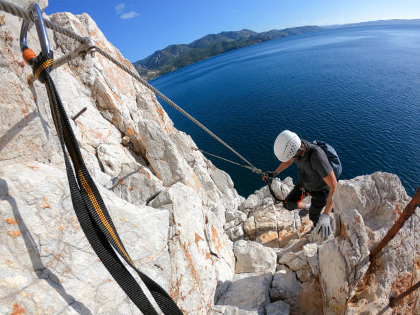 istock Man climbing up via ferrata above sea 1203066253