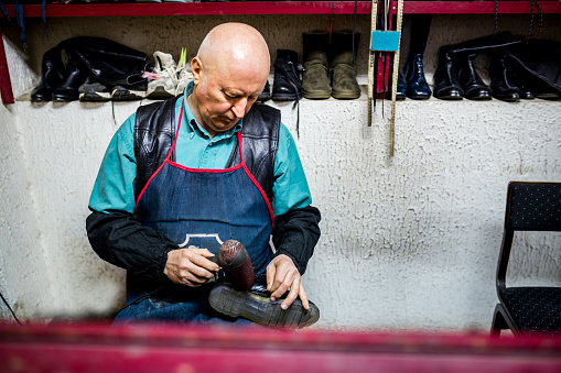 Shoe maker in workshop repair shoe