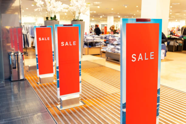 Red bright sale banner on anti-thieft gate sensor at retail shopping mall entrance. Seasonal discount offer in store Red bright sale banner on anti-thieft gate sensor at retail shopping mall entrance. Seasonal discount offer in store. burglar alarm stock pictures, royalty-free photos & images
