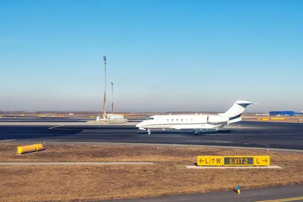 Photo of Mid size modern vip private jet running on rairport runway ready to departure. Pilot asking air traffic control officer for take-off clearance. Luxury small corporate business aircraft trip