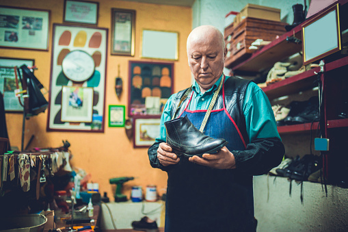 Shoemaker working in his shoe repair shop