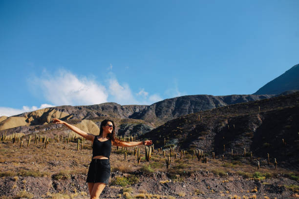 istock Woman posing in front of a cacti field 1203074689