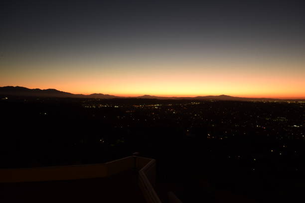 istock Wide Angle View Of Sprawling Illuminated Los Angeles Metropolis Horizon With Mountain Range During Beautifully Vivid Sunrise 1203076328