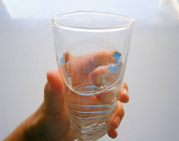 istock A glass of water held in a person's hand 1203076549