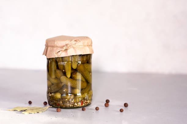 istock Marinated cucumbers gherkins. Pickles with mustard and garlic on a stone background. 1203078718