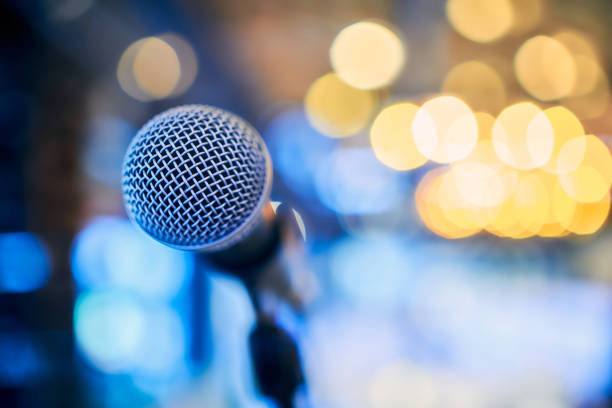 istock Microphone on stage against the background of blurry lights 1203078774