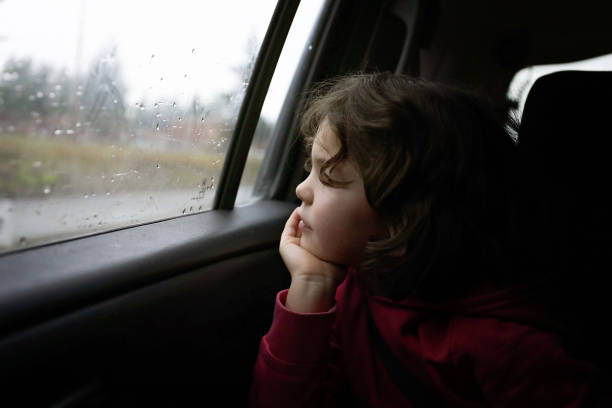 istock Girl looking out car window 1203079994