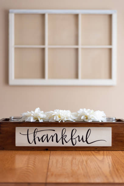 istock White flowers in a rustic wood container with the word thankful 1203081891