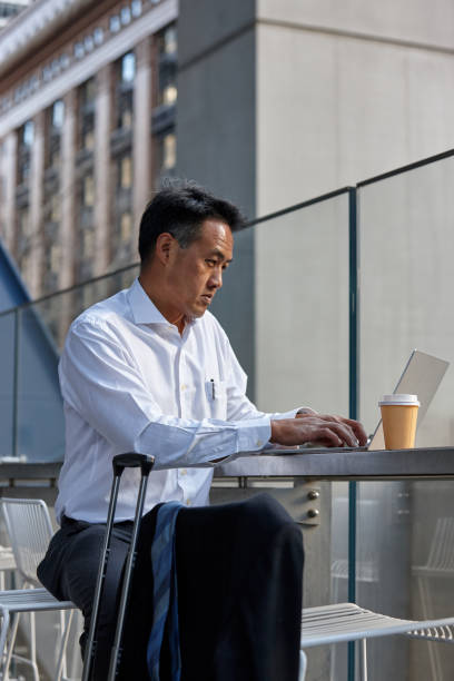 istock Australasian businessman working on laptop outside 1203082133