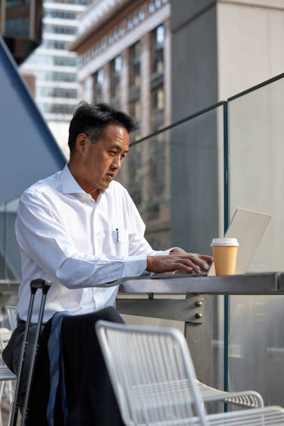 istock Australasian businessman working on laptop outside 1203082137