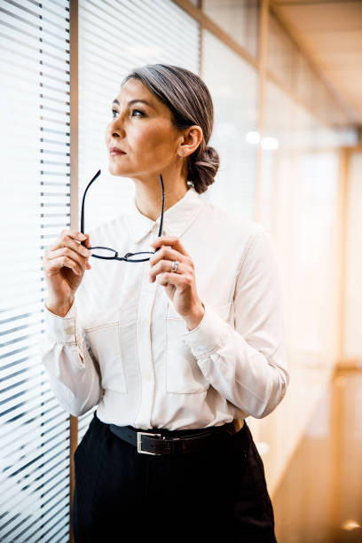 istock Calm lady taking her glasses off at work stock photo 1203084986