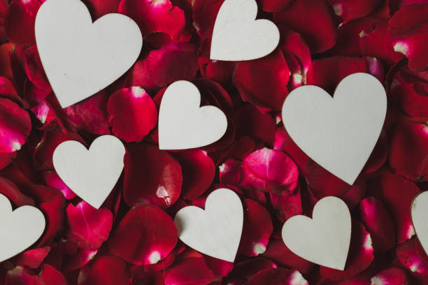 istock White wooden heart Placed on red rose petals 1203086855